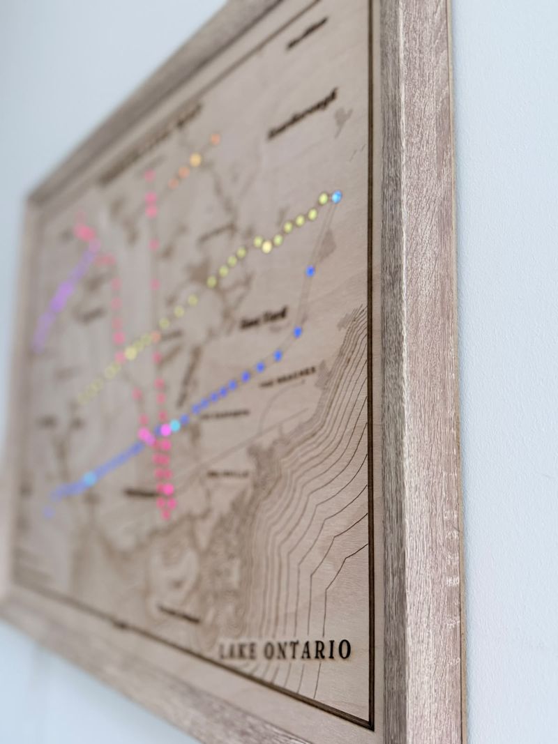 The framed map seen from the side, showing the depth of the wooden frame and the engraved Lake Ontario lettering